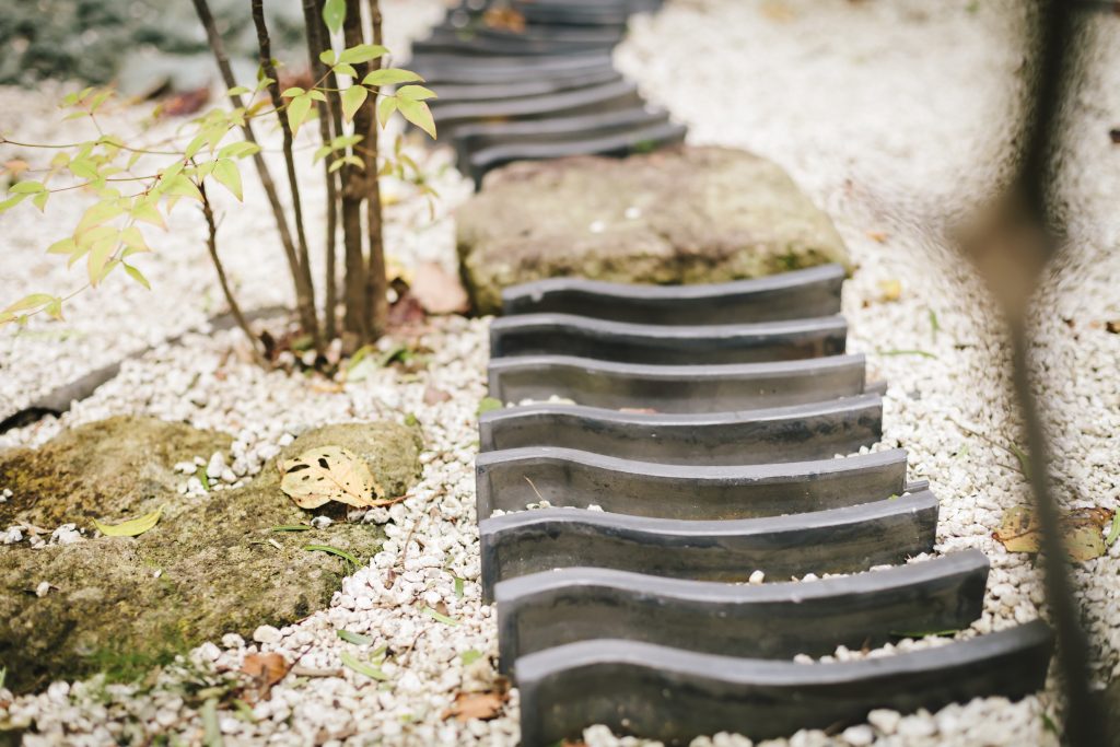 砂利敷きの中庭に瓦を並べた小道